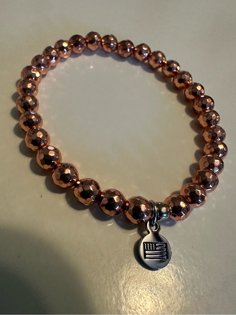 T. Jazelle Rose Gold Colored Faceted Bead Stretch Bracelet with Flag Charm
